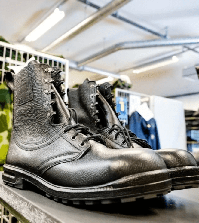 A pair of black leather army-issue boots on a table in a military clothing store